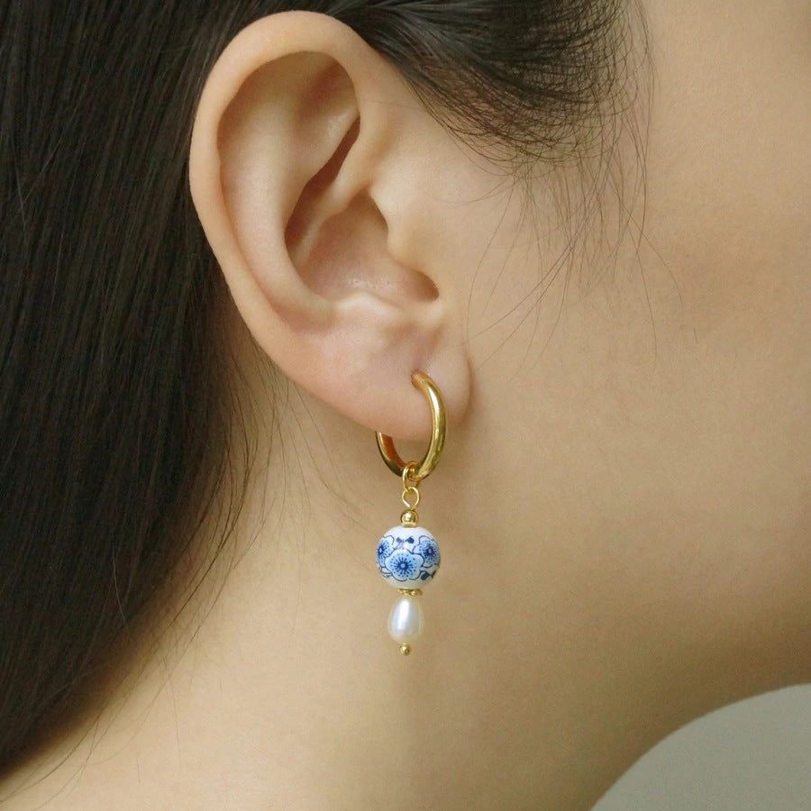 Buy now the Delft blue ceramic earrings from Amore Jewellery! These gold-plated retro earrings with a ceramic pendent and natural pearls have an elegant design!